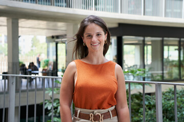 Outdoor portrait of a young smiling and cheerful Caucasian woman. Student girl on college campus....