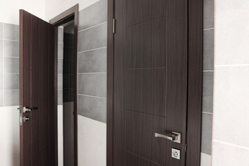 Two brown wooden doors in public toilet