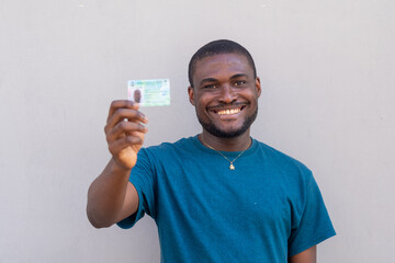 close up of a handsome african man from nigeria holding his voters card
