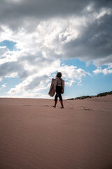 Fototapeta na wymiar african girl walking in the desert dunes