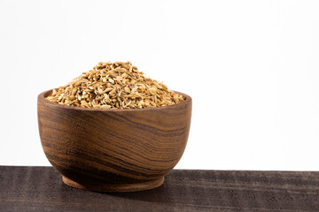 Fennel seeds in a small wooden bowl - Foeniculum vulgare