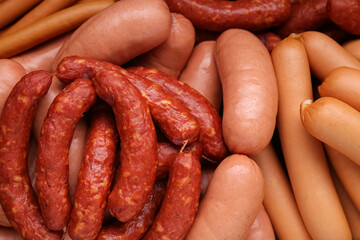Different tasty sausages as background, closeup view