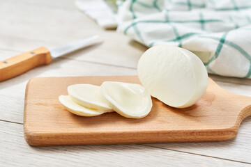 sliced Italian cheese mozzarella buffalo on a white kitchen table.