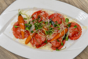 Overhead view of tempting meal of handmade butternut squash ravioli served with romano pecorino cheese