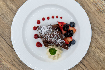 Overhead view of tempting dessert of flourless chocolate cake served with black berries and blueberries