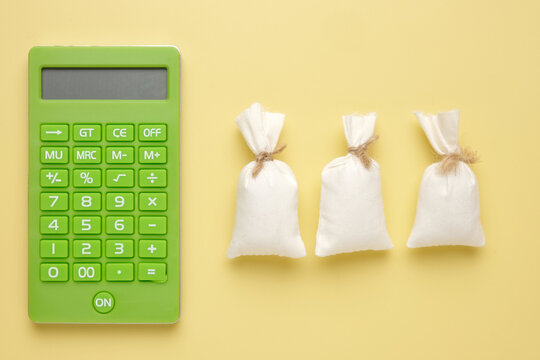 A picture of calculator with 3 money bags. Payroll and NFP concept.