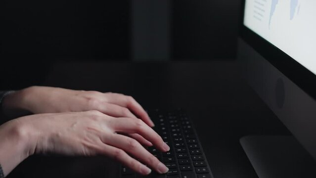 暗い部屋でタイピングする女性