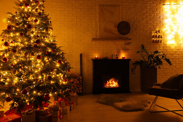 Beautiful Christmas tree with festive lights near fireplace in room. Interior design