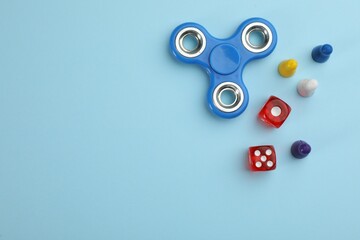 Spinner, dices and pawns on light blue background, flat lay with space for text. Board games...