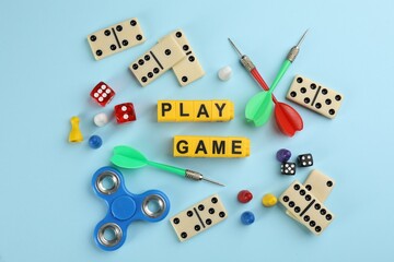 Flat lay composition of blocks with words Play Game on light blue background
