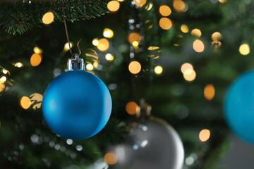 Fototapeta na wymiar Beautiful Christmas balls hanging on fir tree branches, closeup. Space for text