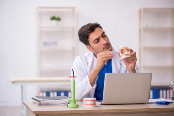 Young male dentist working in the clinic
