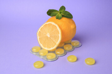 Fresh lemons, mint leaves and blister with cough drops on lilac background