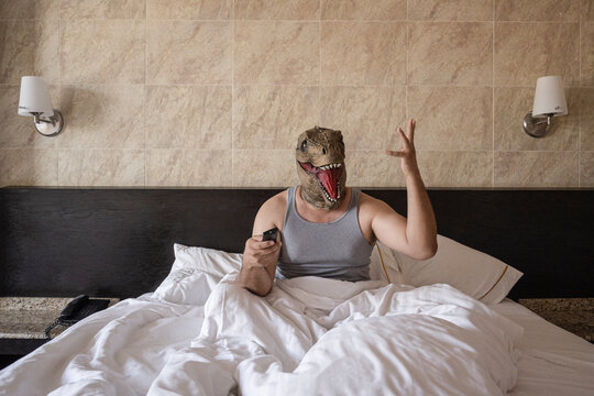 Man With Tyrannosaurus Mask Watching Tv