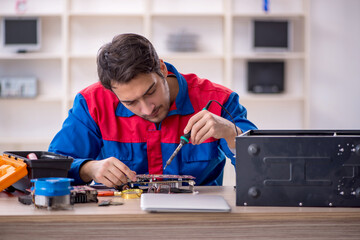 Young male repairman repairing computer