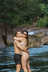 portrait of a fit couple kissing at the river in Australia