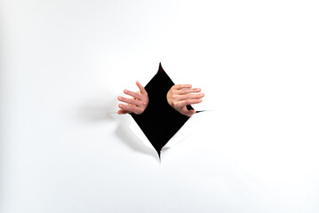 hands reaching through paper