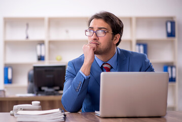 Fototapeta premium Young male employee working in the office