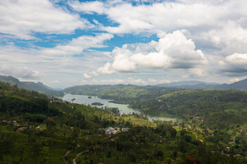Fototapeta na wymiar A lake among the hills with tea plantations in the mountains. Maskeliya, Castlereigh, Sri Lanka.