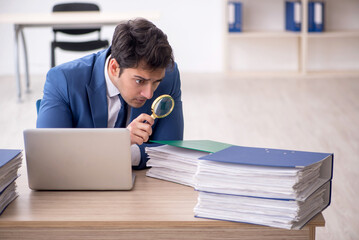 Young male employee and too much work in the office