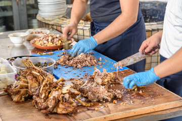 Cookers are cutting meat from plov (pilaf) for serving, Tashkent