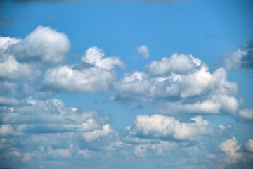 Bright landscape of white puffy cumulus clouds on blue clear sky