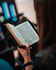 Persona leyendo la biblia mientras escucha la predicación en su iglesia