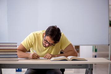 Young male student preparing for exams in the classroom