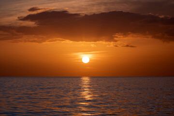 Dramatic red ocean waves at sunset with soft evening sea dark water
