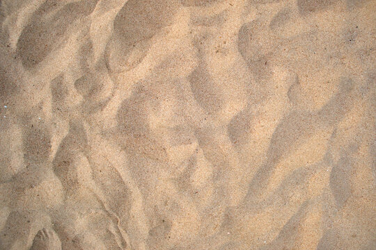 Flat view of clean yellow sand surface covering seaside beach. Sandy texture