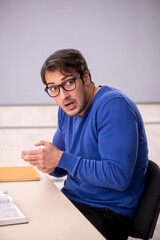 Young male student preparing for exams in the classroom