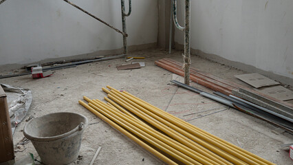 Yellow PVC pipe piled up in a construction building. along with other construction equipment placed...