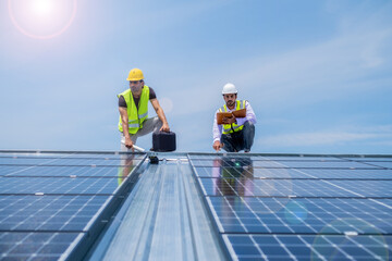 Engineer looking pad to check system of solar cell pannel after installed on roof, worker with solar plate againt beautiful blue sky for advertising.