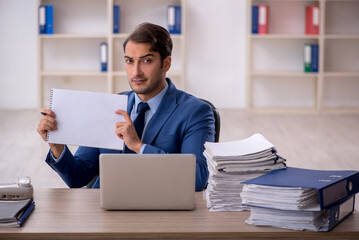 Young male employee and too much work in the office