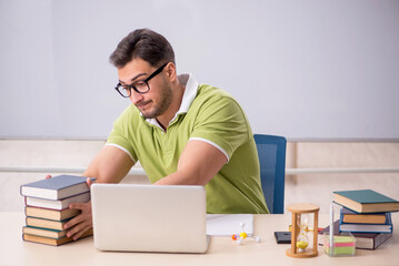 Young male student preparing for exams in the classroom