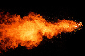 Fototapeta na wymiar Orange powder explosion on black background.Orange color dust splash.