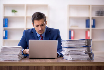 Young male employee and too much work in the office