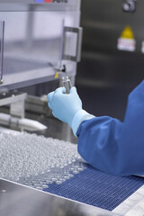 a hand in a medical latex glove holds a glass ampoule for vaccines. Medical glass vials. Close-up....