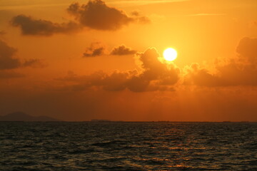 Sunset over the sea on the sky with sun shine ray pass orange cloud in the evening