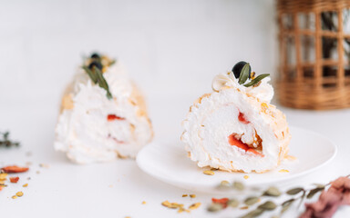 Meringue roll without sugar on a white plate cut into pieces.