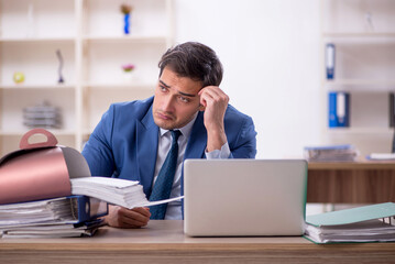 Young male employee eating cake at workplace