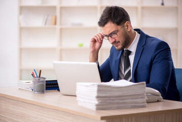 Fototapeta premium Young male employee working in the office