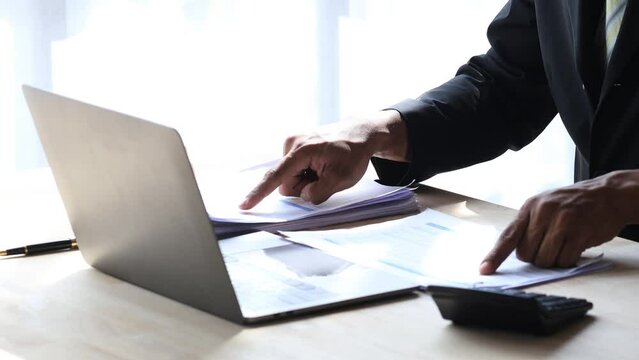 Businessman working, businessman looking at business documents and checking company finances, young startup company executive. Startup business management concept.