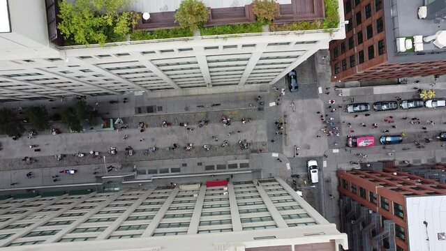 a aerial view drone shot of a street in the area of the dumbo in brooklyn, in the new york city with the people walking and roofs with gardens nyc