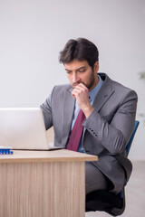 Young male employee sitting in the office