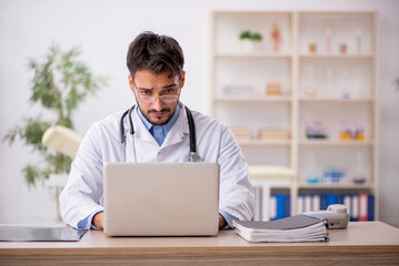 Fototapeta premium Young male doctor in telemedicine concept