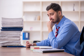 Young male employee unhappy with excessive work in the office