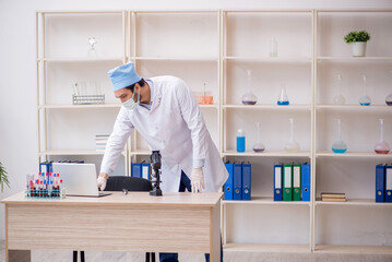 Young male chemist working at the lab