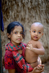 asian sister with brother, South Asian little kid playing in front of his house, cute little...