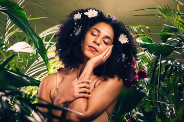 Beauty, flowers and black woman in studio for wellness, skincare and creative advertising in a jungle. Facial, skin and girl model relax in zen, peace and products from nature, forest and aesthetic